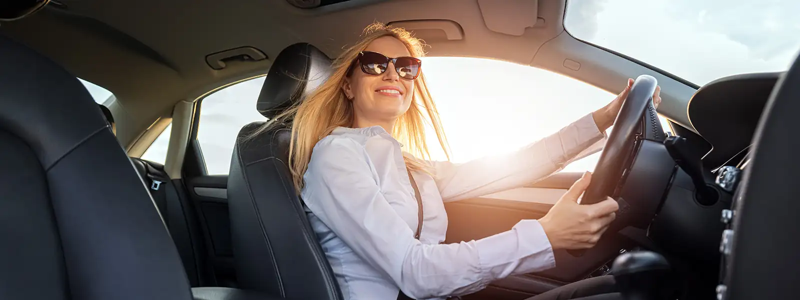 Woman Driving a Car Down a Sunny Road