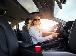 Woman Driving a Car Down a Sunny Road